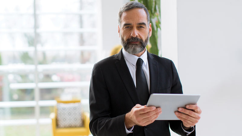 homem de fato com tablet na mão